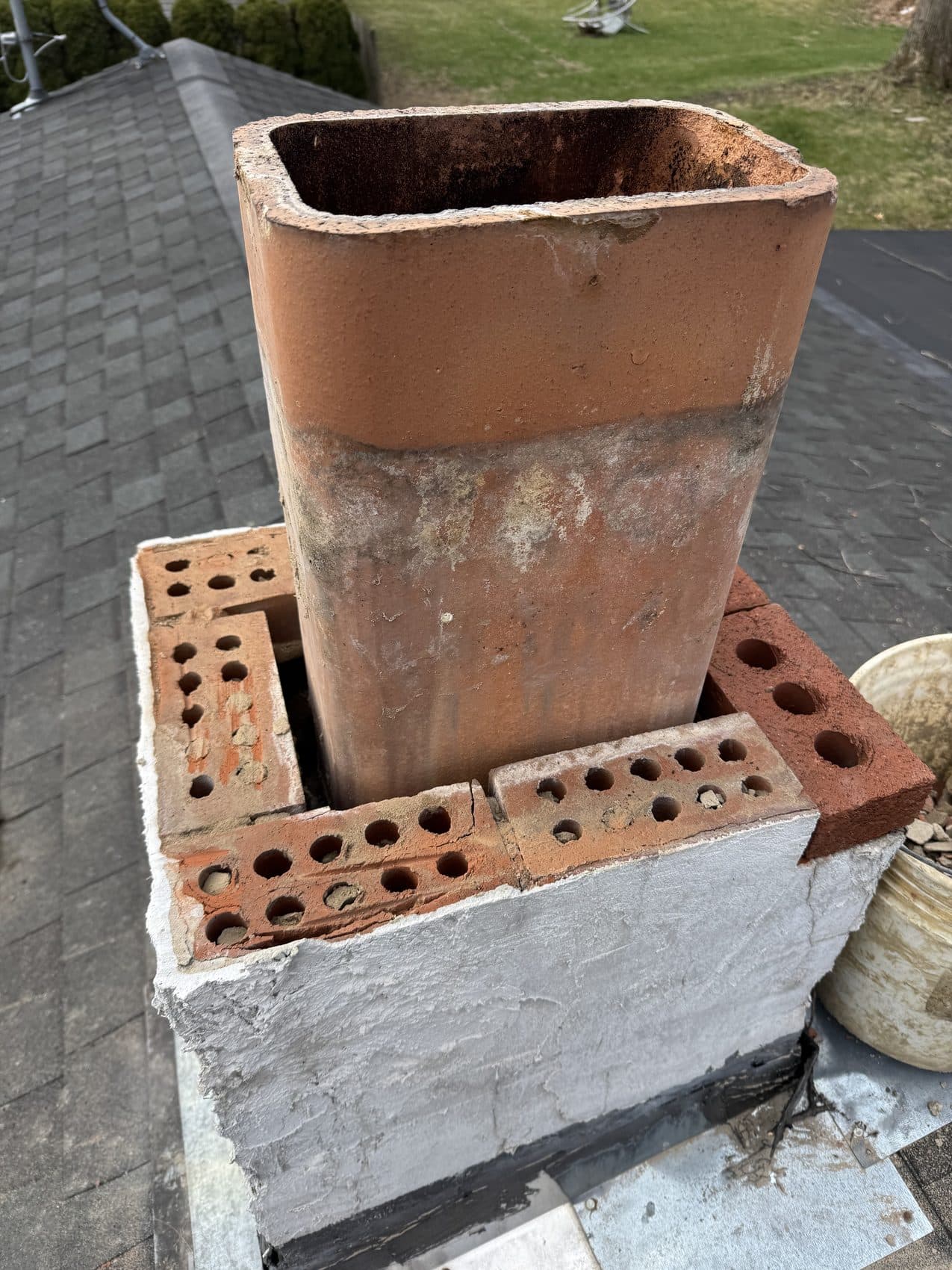 Old clay flue tile exposed on a chimney with the crown removed, ready for rebuild