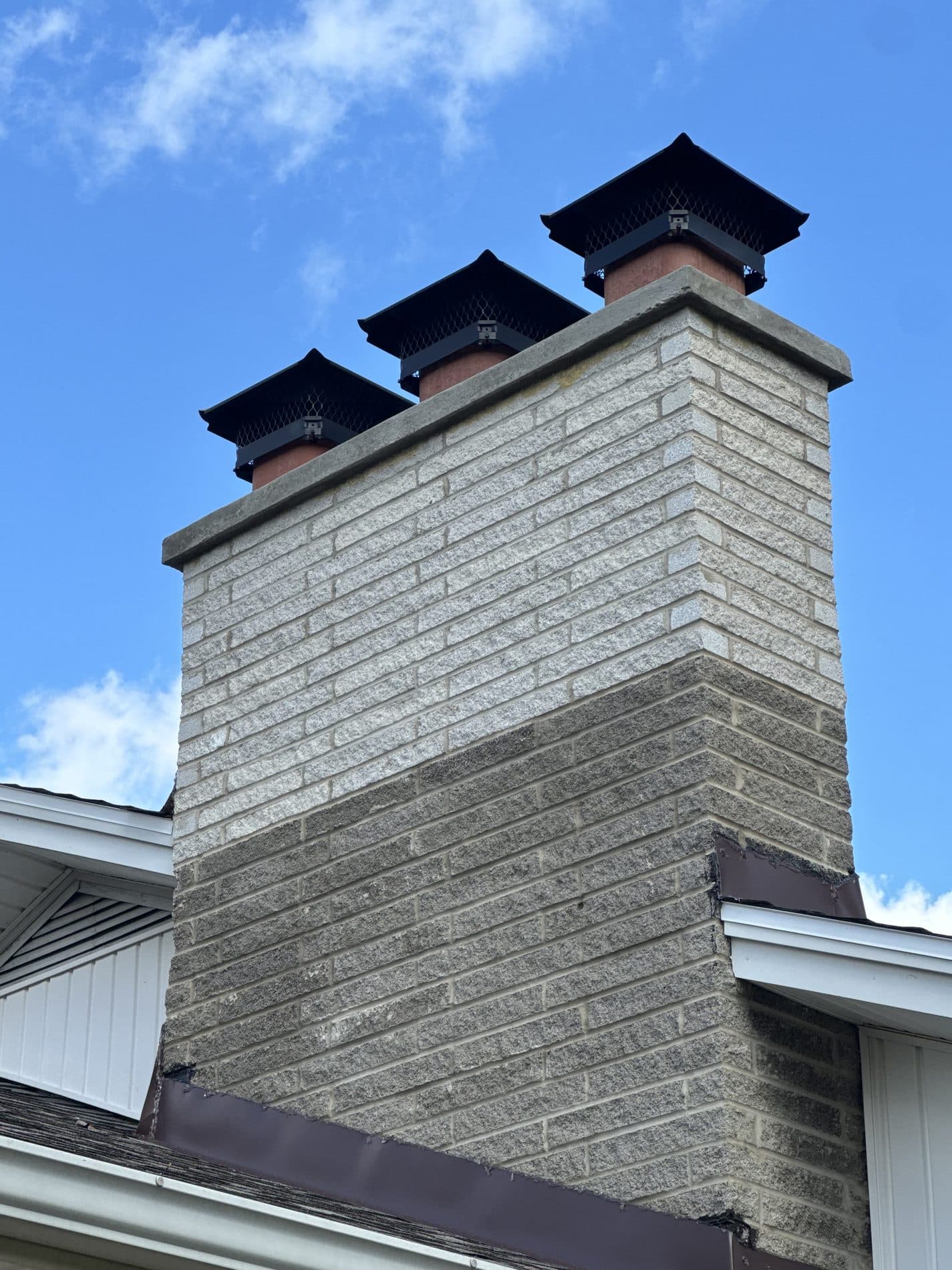 Rebuilt chimney in gray-buff brick with three new black caps