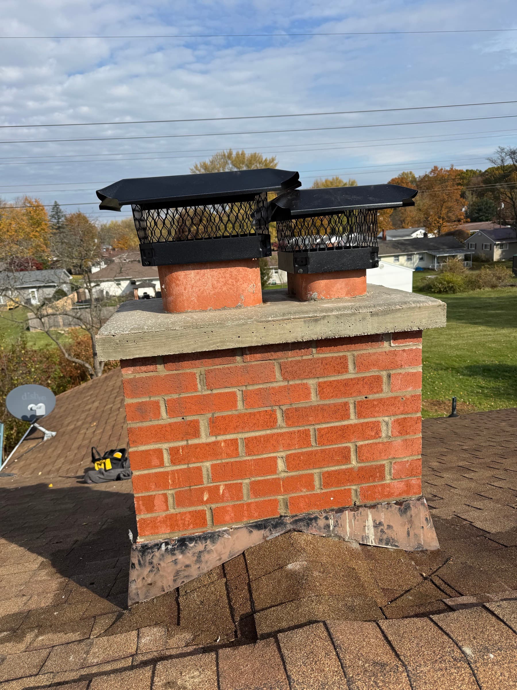 After: the same chimney fully rebuilt with a new crown, two caps, and new flashing